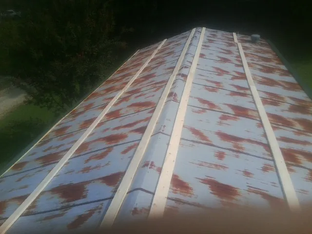 Rusted metal roof panels with new wood purlins before replacement — Storm Damage Roof Repair in Willow Creek by Roofing Brothers