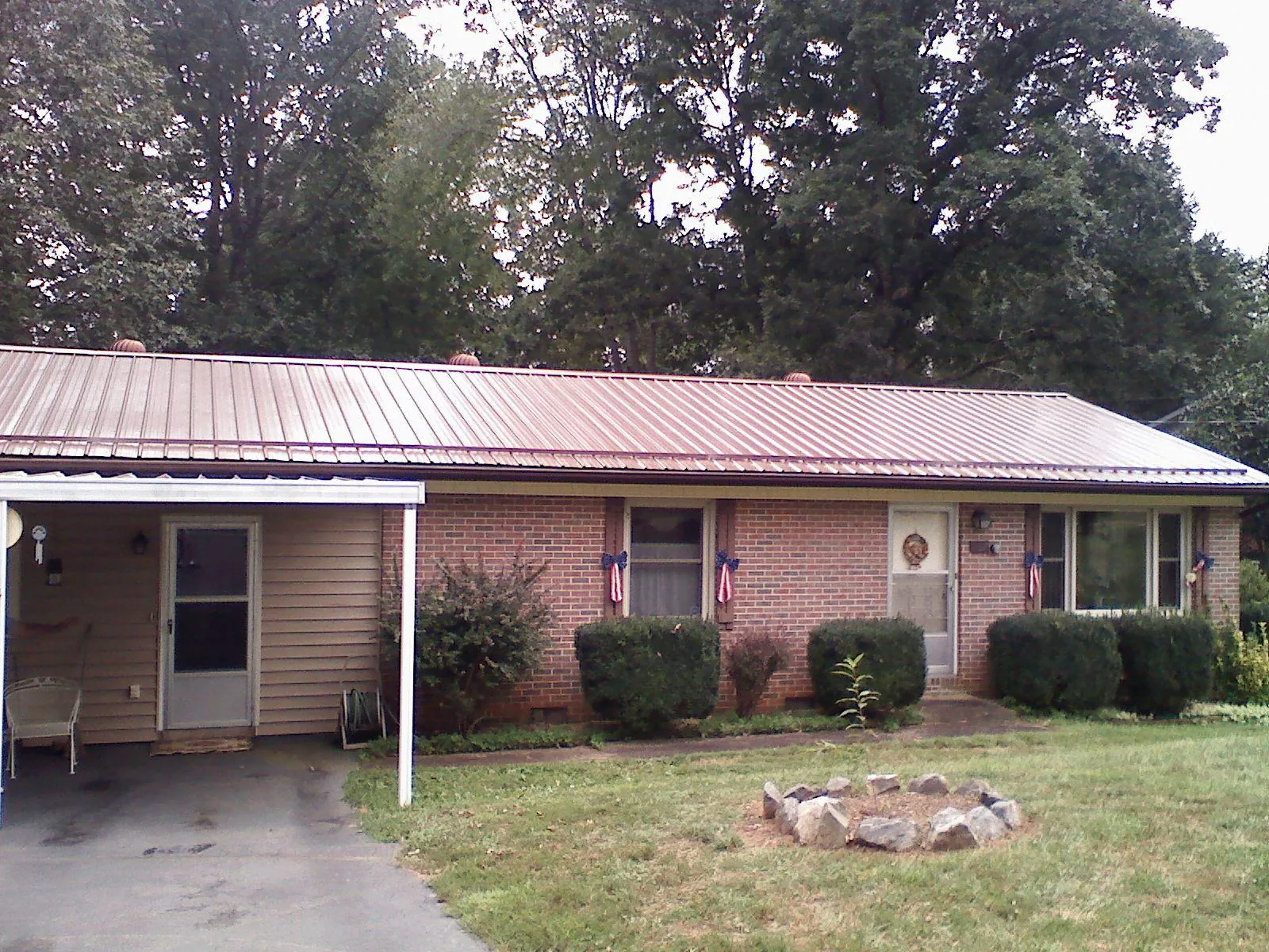 Bronze metal roof and carport on a brick ranch home — Roof Repair work by our crew in Willow Creek